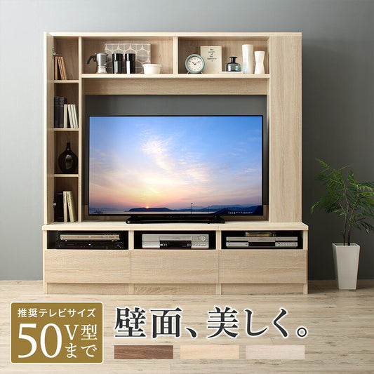50V型まで対応の壁面収納テレビボード。明るい木目調で、テレビ上部と左側に飾り棚、下部にAV機器収納と引き出しを備えた設置イメージ
