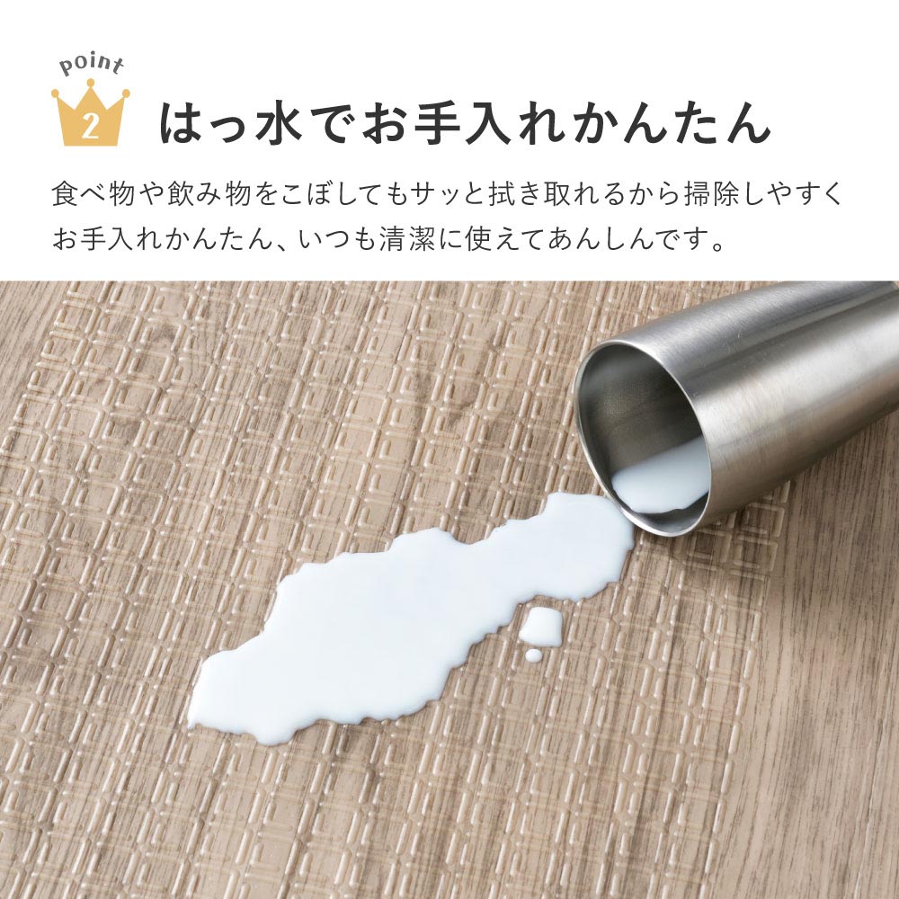 木目調のプレイマットに飲み物をこぼした様子と、さっと拭き取れるはっ水仕様の紹介